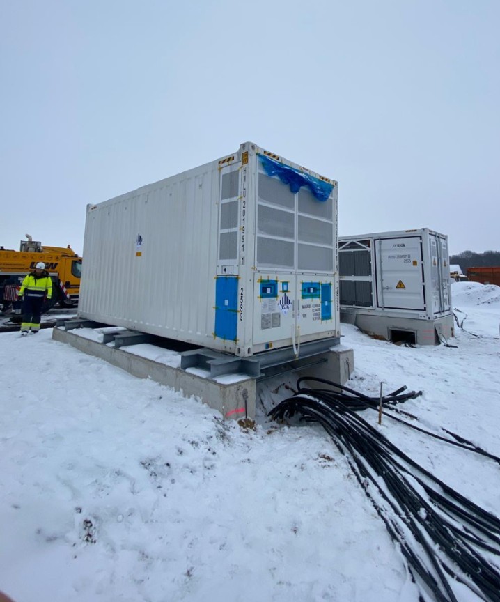 Batteriespeicher-Container auf Fundament mit Kabelanschluss im Schnee